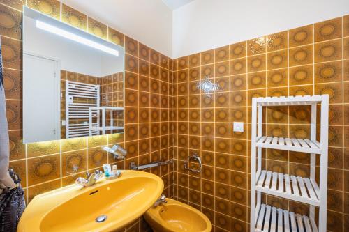 a bathroom with a yellow sink and a mirror at Gîte Le Scaphandre in Espalion