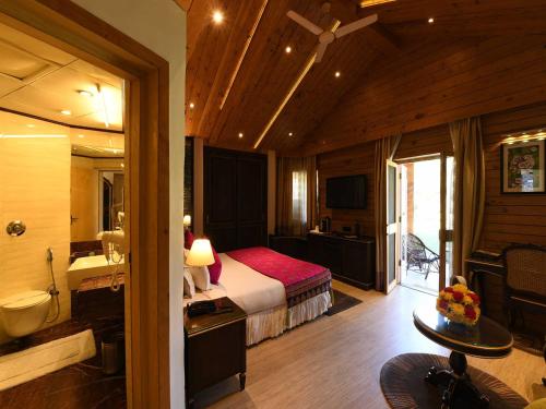 a hotel room with a bed and a bathroom at Span Resort & Spa, Manali - A Luxury Riverside Resort in Manāli