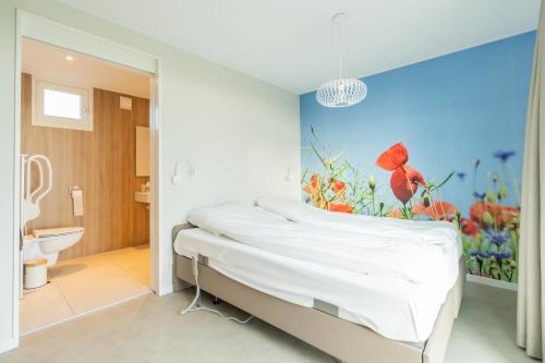 a bedroom with a bed with a painting on the wall at Buitenplaats Oudendijke in Ellemeet