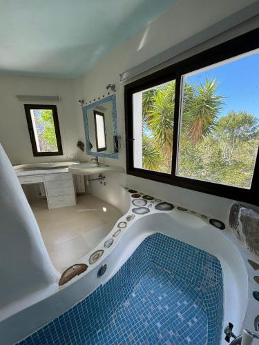 a large bathroom with a tub and a large window at Can Iara in Sant Miquel de Balansat