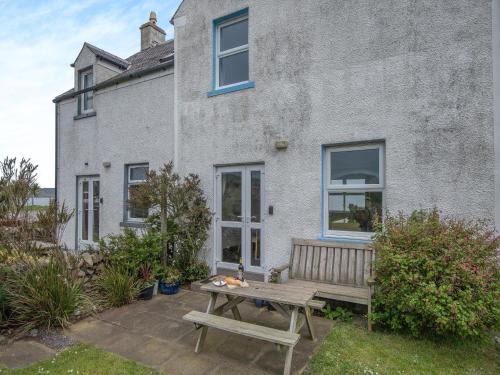a wooden bench in front of a house at Jura in Drummore