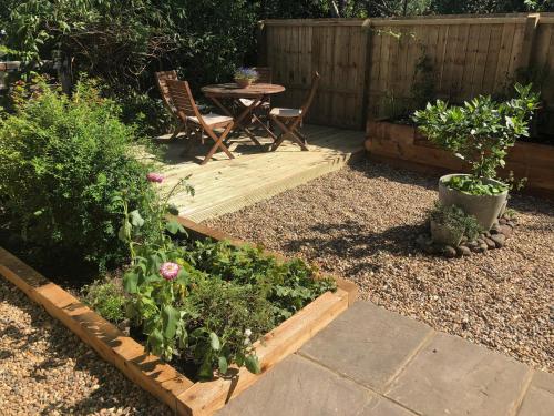 a garden with a table and chairs and plants at Crown Cottage in Hartest