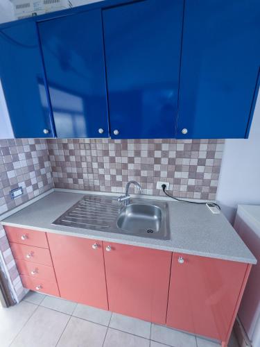 a kitchen counter with a sink and blue cabinets at Sunrise Dhermi Beach in Dhërmi