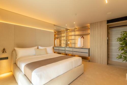 a bedroom with a large white bed and a closet at OPUS Batumi in Batumi