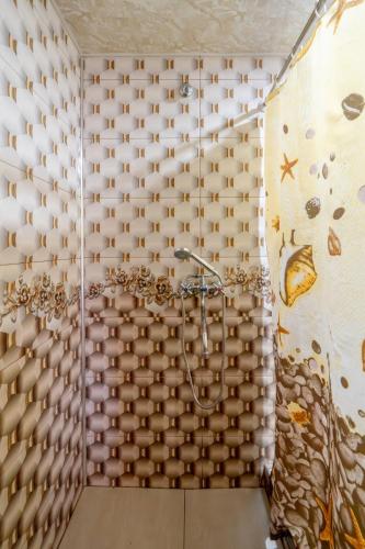 a bathroom with a shower with a wall at NNN Guest House in Goris