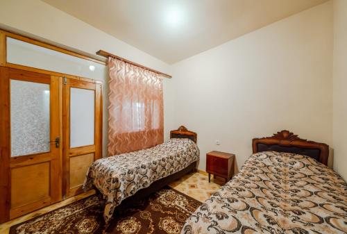 a bedroom with two beds and a window at NNN Guest House in Goris