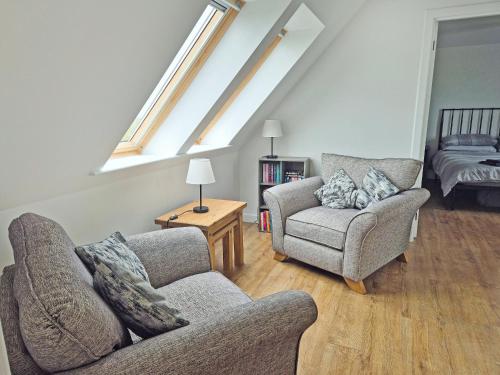 a living room with two chairs and a couch at Husabost House in Carinish