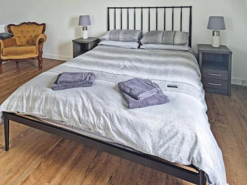 a large bed with two purple towels on it at Husabost House in Carinish