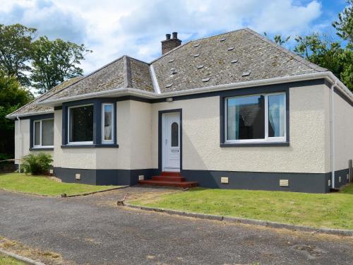 a small white house with a door at Stronvaar in Stranraer