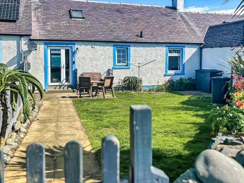a house with a table and chairs in the yard at Gigha in Drummore