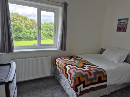 a bedroom with a bed and a window at private room with shared bathroom 20 minutes walk to Durham centre in Gilesgate
