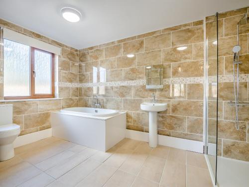a bathroom with a toilet and a sink and a shower at Hawthorn Lodge - Uk42546 in Llanwrthwl