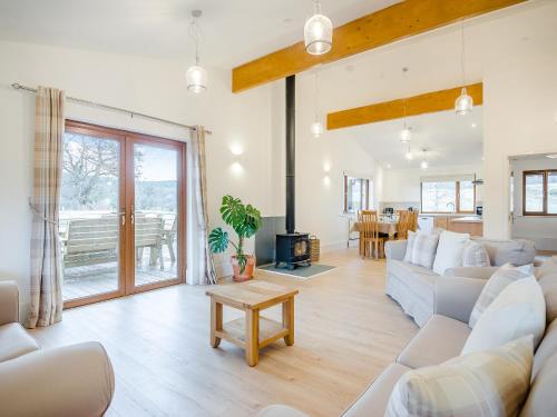 a living room with a couch and a table at Hawthorn Lodge - Uk42546 in Llanwrthwl