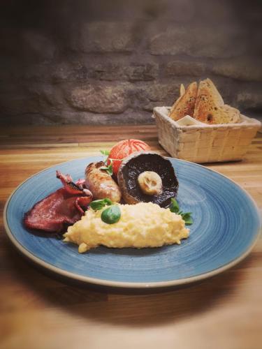 a blue plate with breakfast food on a table at The Crown Inn in Peterborough