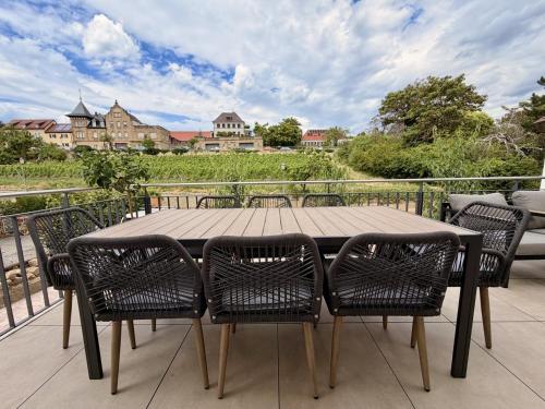 a wooden table and chairs on a balcony with a view at Gimmeldinger Haus in Neustadt an der Weinstraße