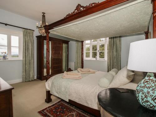 a bedroom with a bed and a table with a lamp at The Butlers Quarters in Much Wenlock