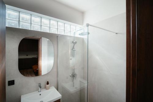 a bathroom with a sink and a shower and a mirror at Aida's Apartment Nafplio in Nafplio