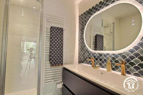 a bathroom with a sink and a mirror at Ker helios in Dinard