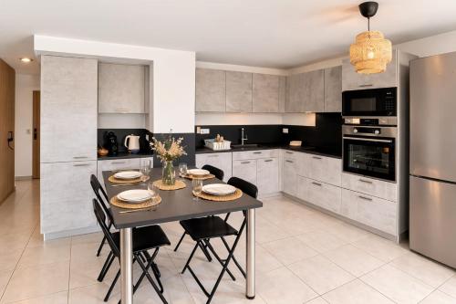 a kitchen with a table and chairs and a refrigerator at The Ill in Softness calm & elegant in Illkirch-Graffenstaden