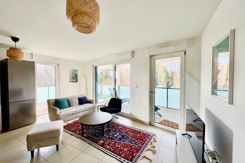 a living room with a couch and a table at The Ill in Softness calm & elegant in Illkirch-Graffenstaden