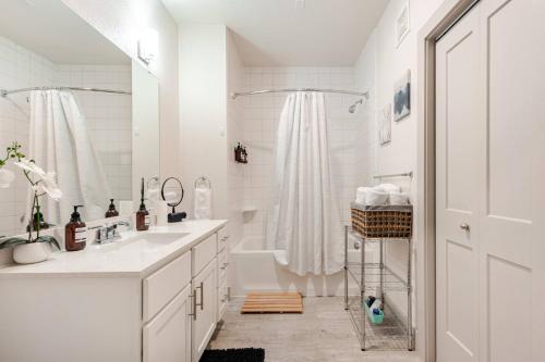a white bathroom with a sink and a shower at Riverwalk View Luxe Condo Views Pool Free Parking in San Antonio