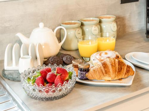 a breakfast table with fruit and croissants and orange juice at Craven Bungalow in Allerston