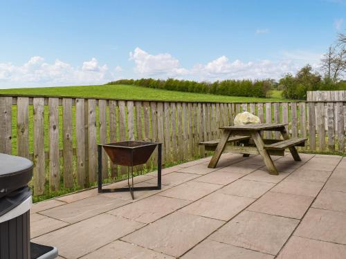 a picnic table and a bench in front of a fence at The Lune - Uk47035 in Kirkby Lonsdale