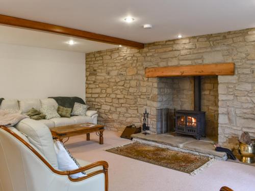 a living room with a couch and a fireplace at Wren Cottage in Lydney