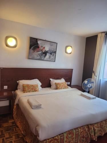 a bedroom with a large bed with white sheets at Lantana Luxe in Nairobi