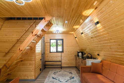 a living room with a staircase in a wooden house at Capsule & Enesai Hotels Karakol in Karakol