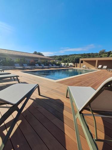 a swimming pool with chairs on a wooden deck at Hotel Fazio in Bonifacio