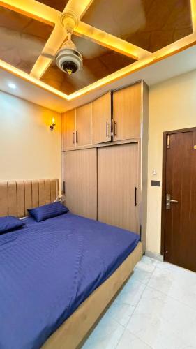 a bedroom with a blue bed and a ceiling at Complete Comfy House with 3 beds Al-Hafeez Garden Lahore in Lahore