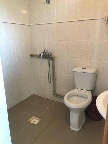 a bathroom with a white toilet and a sink at Aiperii in Bosteri
