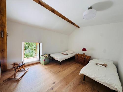 a bedroom with two beds and a window at La Masure in Les Rameaux