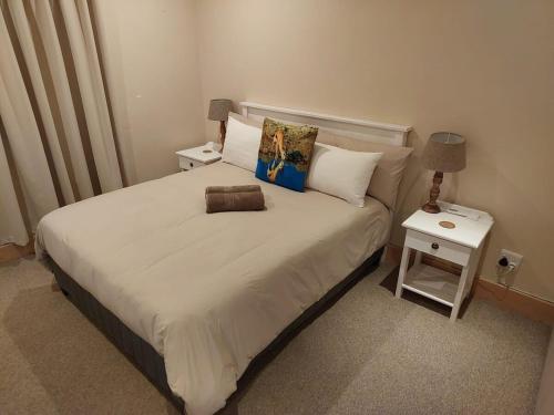 a bedroom with a large bed with two night stands at Springbok Cottage in Graaff-Reinet