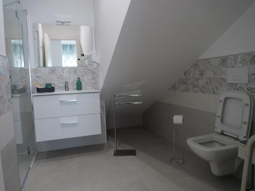 a white bathroom with a toilet and a sink at Mgd House in Santa Domenica