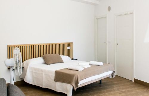 a white bedroom with a bed with towels on it at A Calexa Sarria nº2 in Sarria