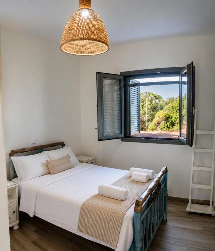a bedroom with a bed and a window at Olive Coast Houses in Kyparissia