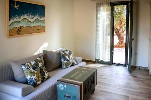 a living room with a couch with a box on it at Olive Coast Houses in Kyparissia