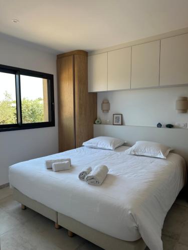 a bedroom with a large white bed with two towels on it at Villas Vangarone in Lecci