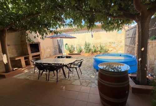 a patio with a table and chairs and a pool at Casa Rural Parajes del Júcar in Casas de Benítez