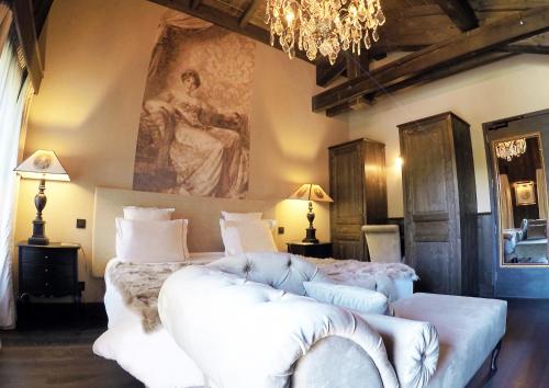 a bedroom with a bed with a couch and a painting at Hotel Le Castel in Chamonix
