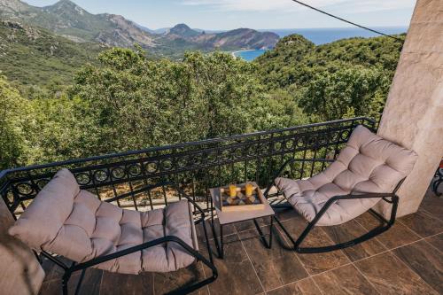 two chairs on a balcony with a view of the mountains at Villa Robinson in Petrovac na Moru