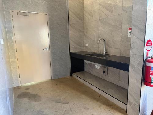 a small bathroom with a sink and a door at Darwin city Studio in Darwin