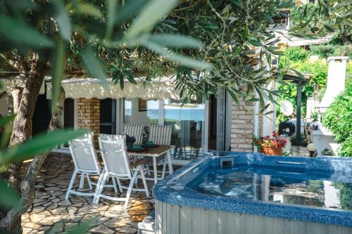 a patio with chairs and a swimming pool at Corfu Dream Holidays Villas in Glyfada