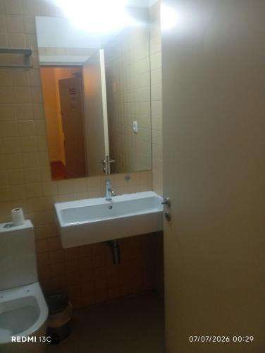 a bathroom with a sink and a toilet and a mirror at Telhado solitario in Porto