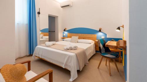 a bedroom with a bed and a table and a desk at Cava del Mare in Favignana