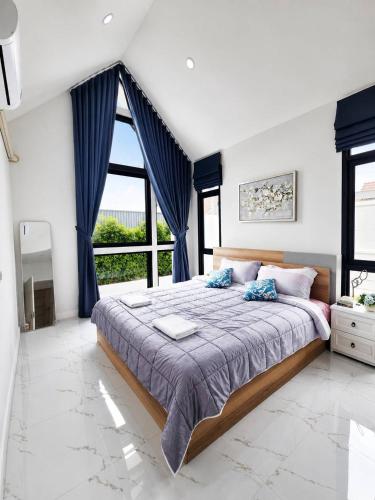 a bedroom with a large bed with blue curtains at X2 privacy villa in Khon Kaen