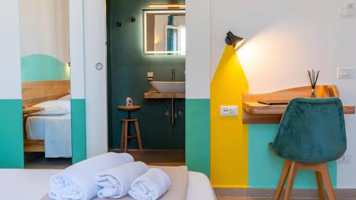 a room with a bed and a desk and a sink at Cava del Mare in Favignana