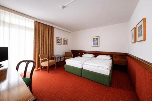 a hotel room with a bed and a table at Kurzentrum Ludwigstorff GmbH in Deutsch Altenburg